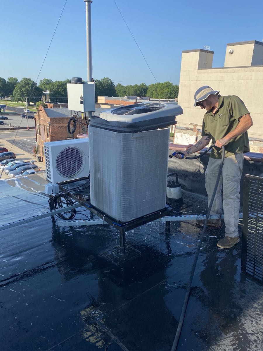 H & H technician servicing a rooftop commercial HVAC unit above downtown Paducah