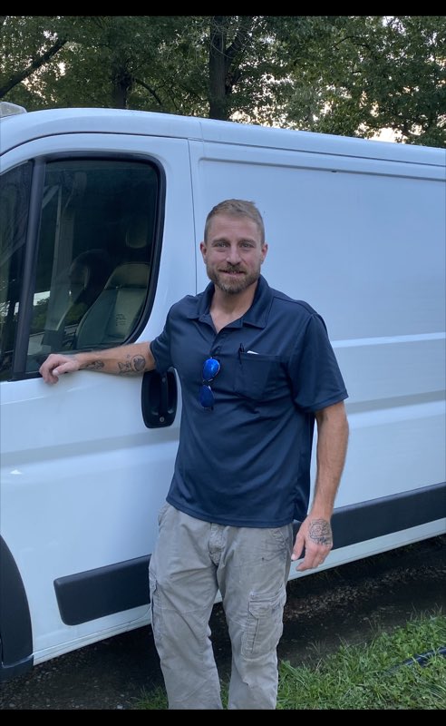 H & H technician standing beside the service van